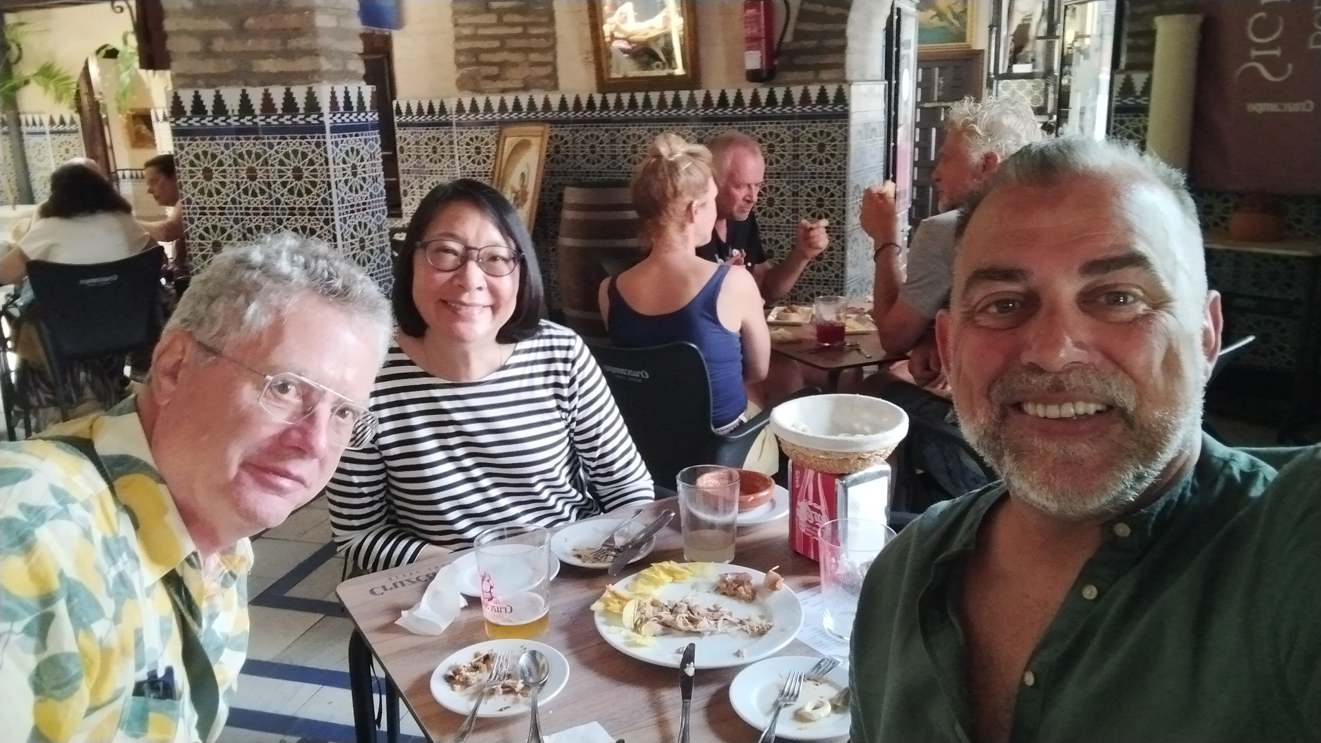 Johnny sharing tapas lunch with guests in a tiled tavern