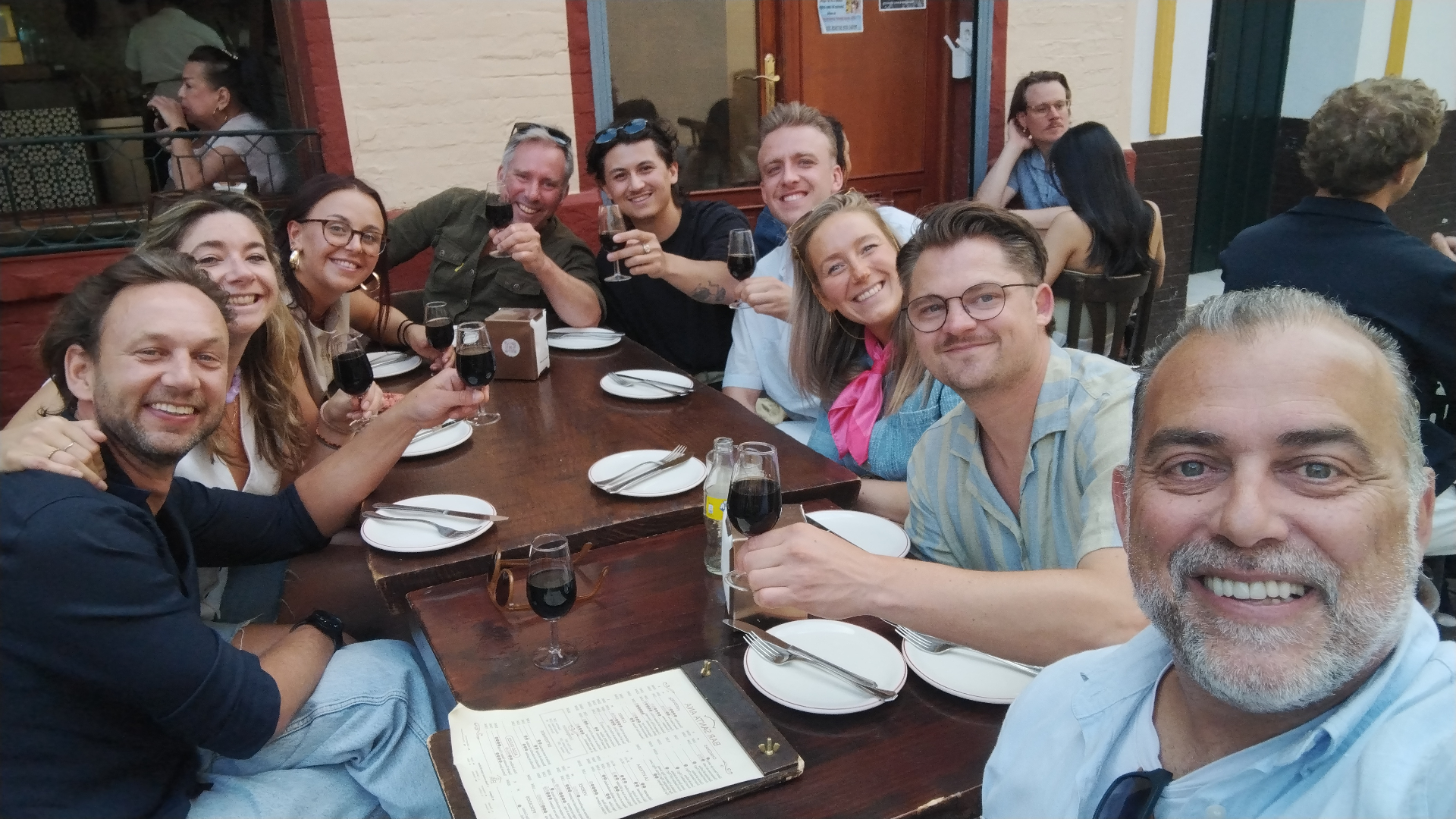 Johnny at a long table with a large group of guests
