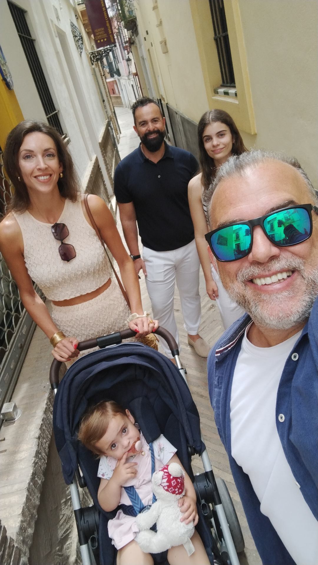 Johnny with a family and stroller in a narrow Sevillian street