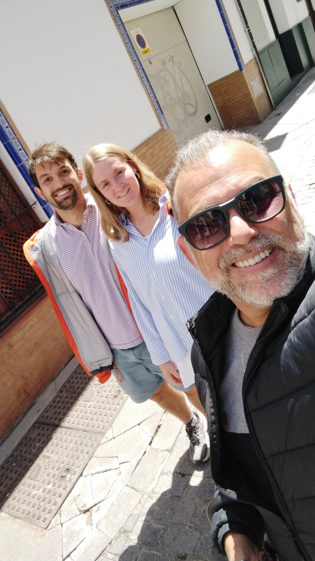 Johnny with a couple in a tiled Sevillian street