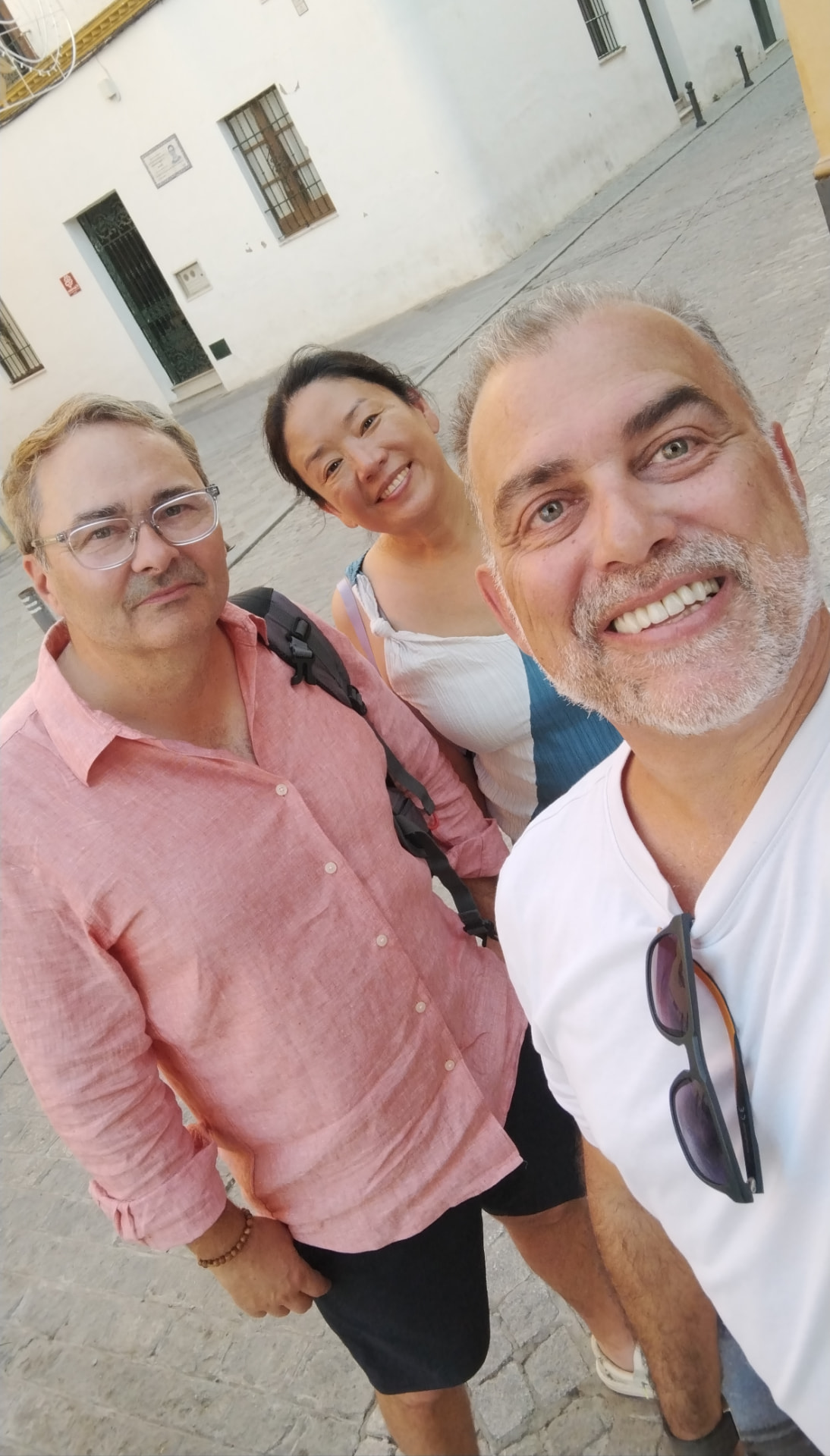 Johnny with three travelers in a whitewashed old town street in Seville