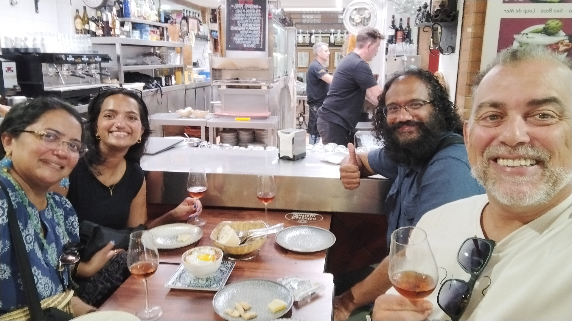 Johnny sharing wine and tapas with guests at a Seville bar