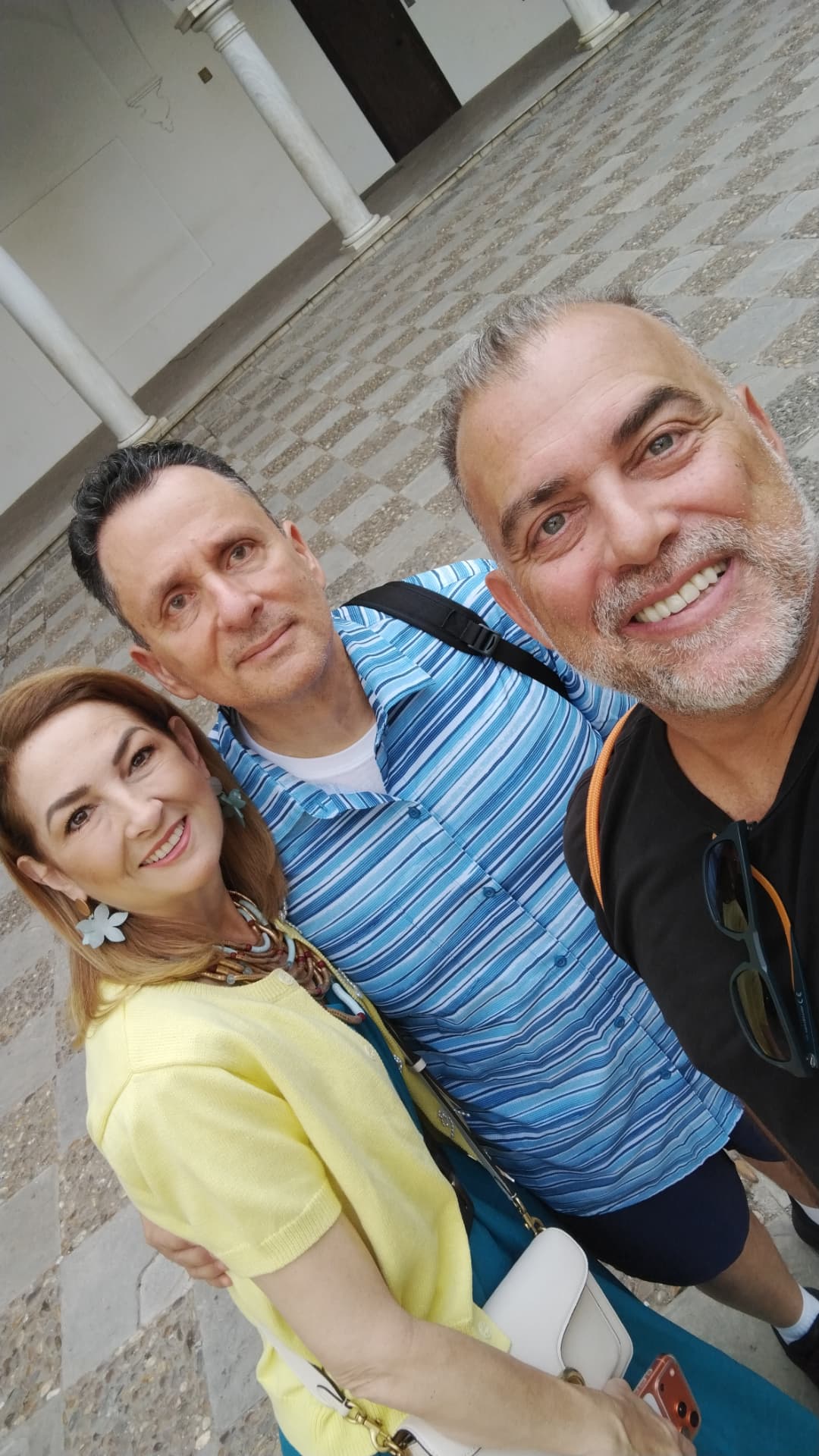 Johnny with a couple in a columned courtyard in Seville