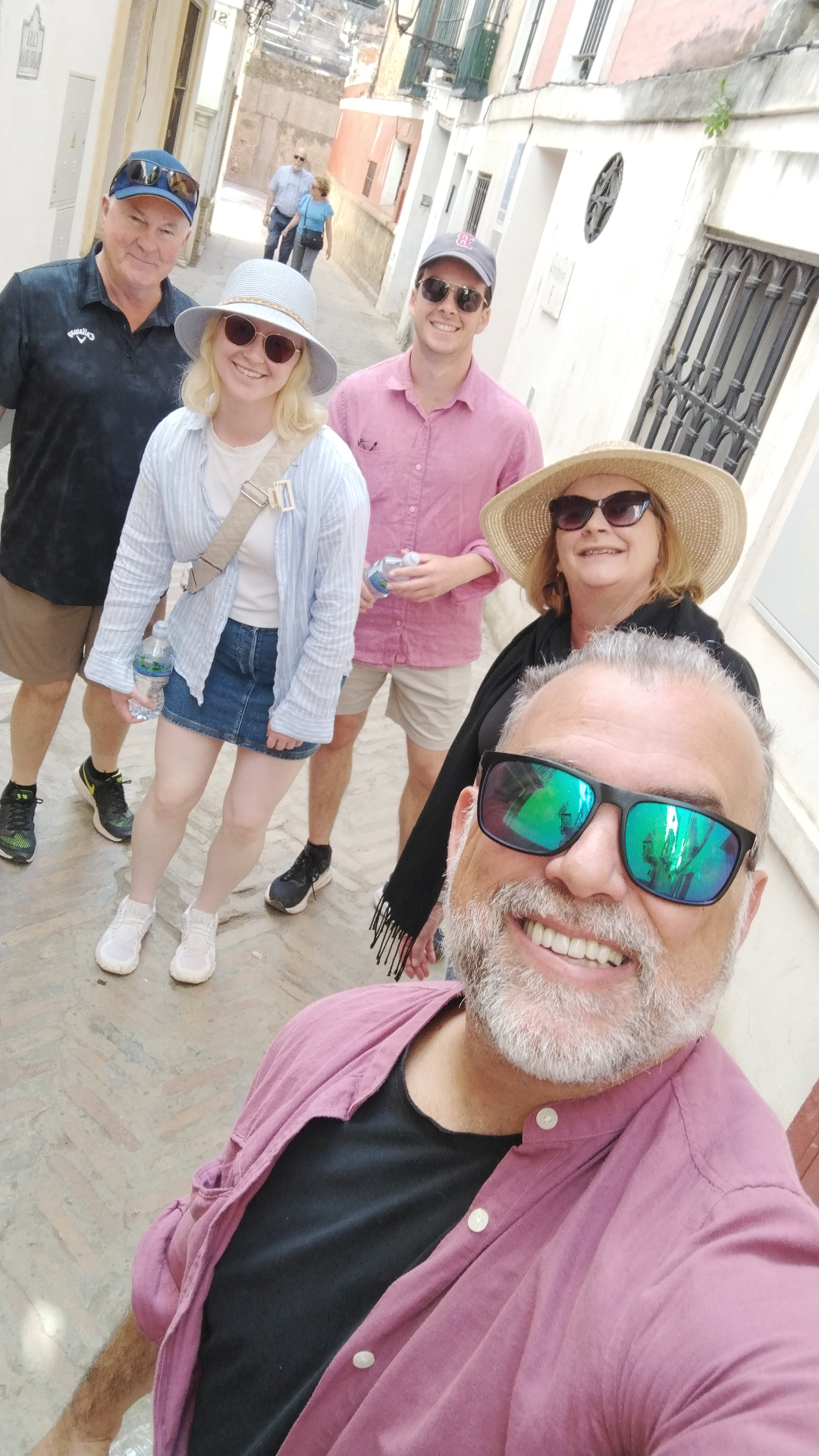 Johnny with a family group in a sunlit Seville alley