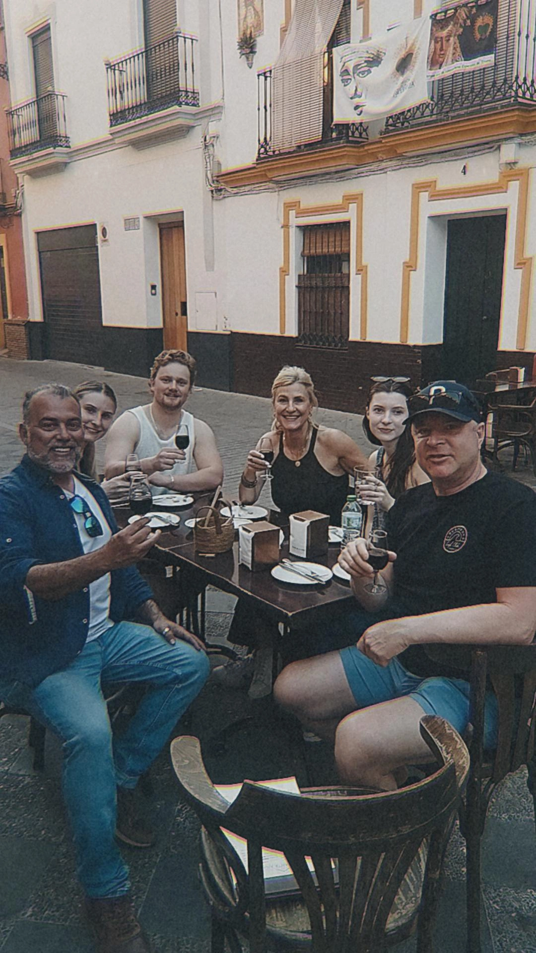 Johnny sharing wine with guests at an outdoor table in Triana